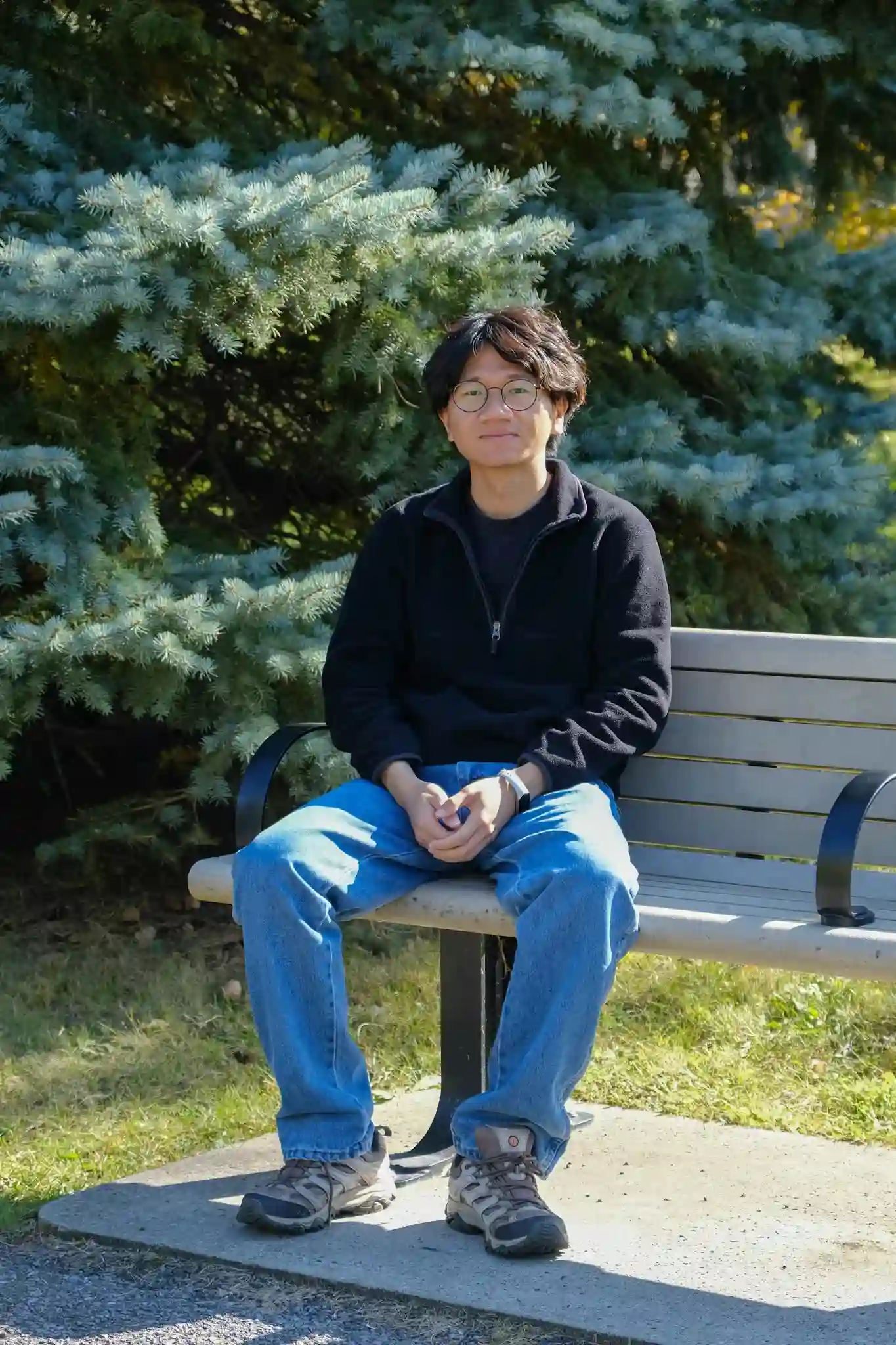 Sherman sits on a chair in the park and smiles